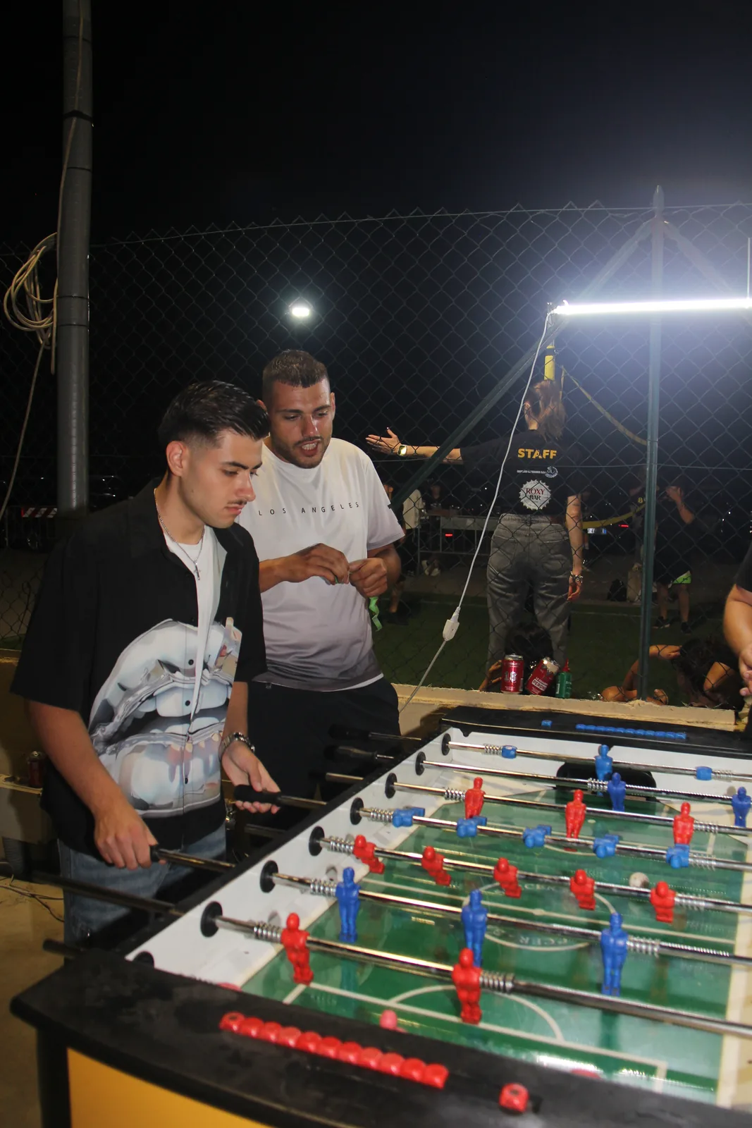 Due partecipanti giocano a calcio balilla durante la serata di La Fossa Games.