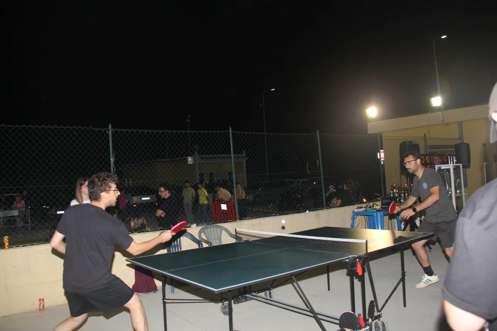 Due partecipanti si affrontano a ping pong nell’area esterna dell’evento.