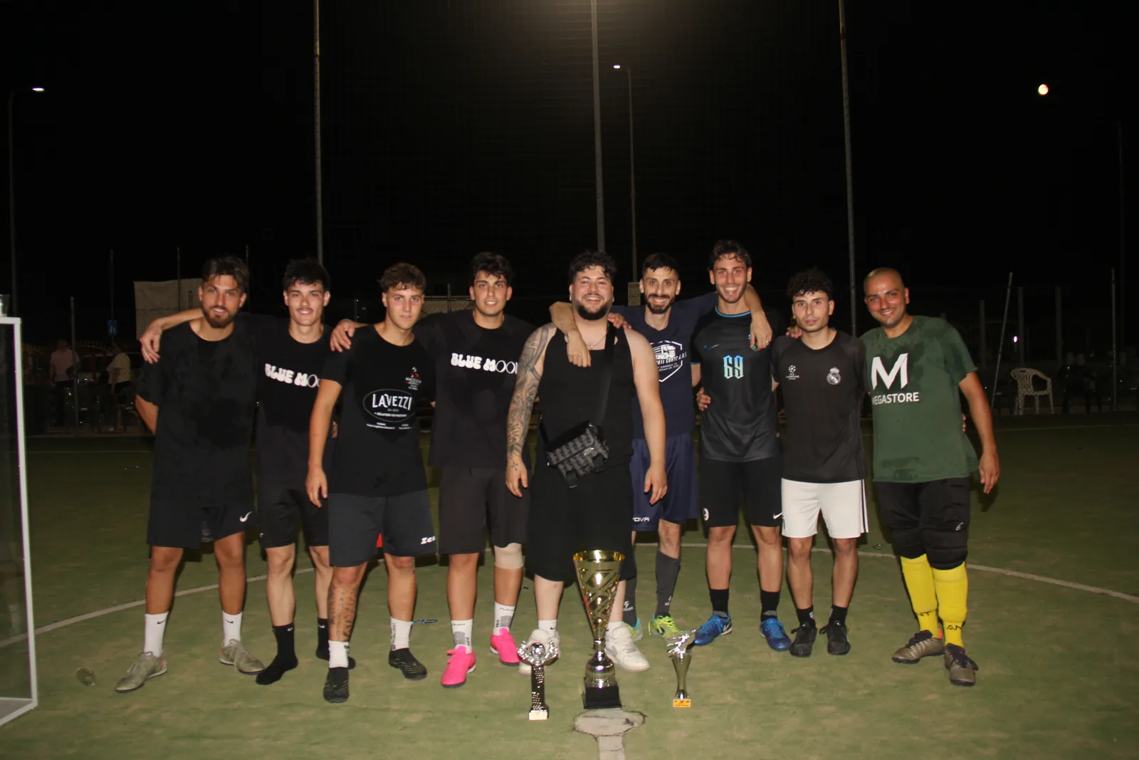 Una squadra di calcio a 5 posa insieme sul campo al termine del torneo.