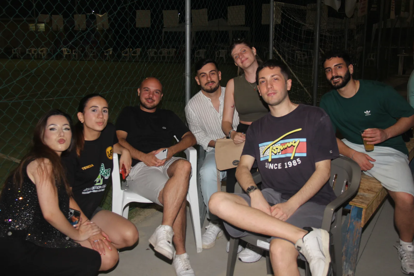 Un gruppo di amici sorride seduto tra il pubblico di La Fossa Games.