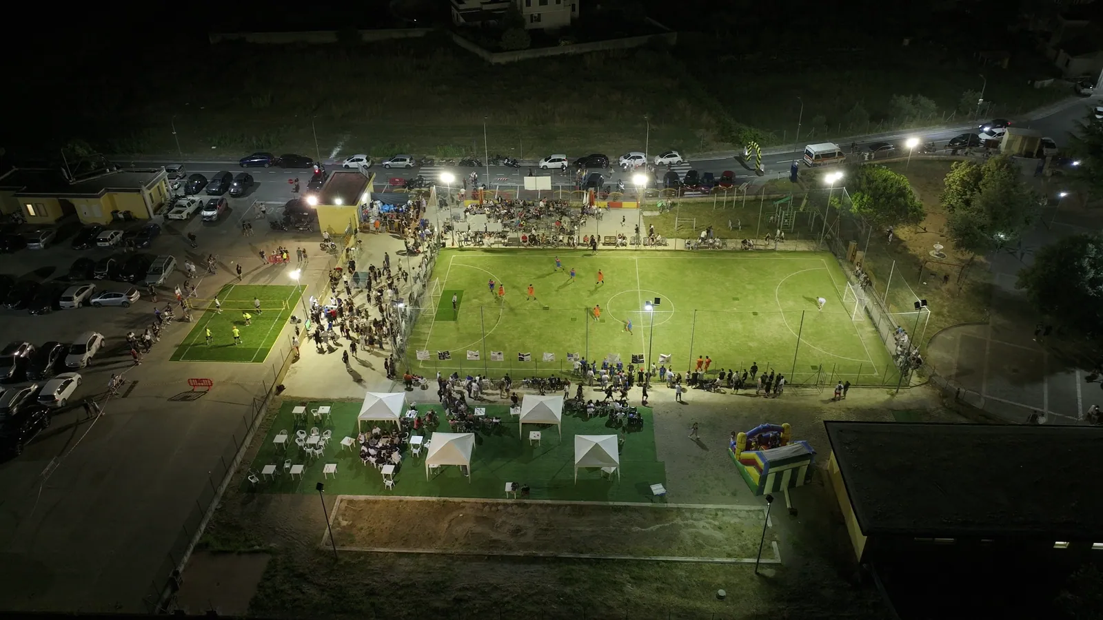 Il campo comunale pieno di giocatori e pubblico durante una serata di La Fossa Games.