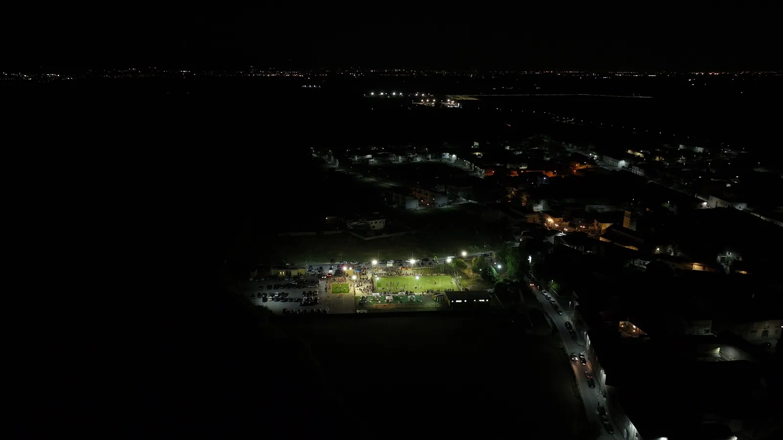 Il campo illuminato nella notte, visto dall’alto insieme a Santa Maria La Fossa.